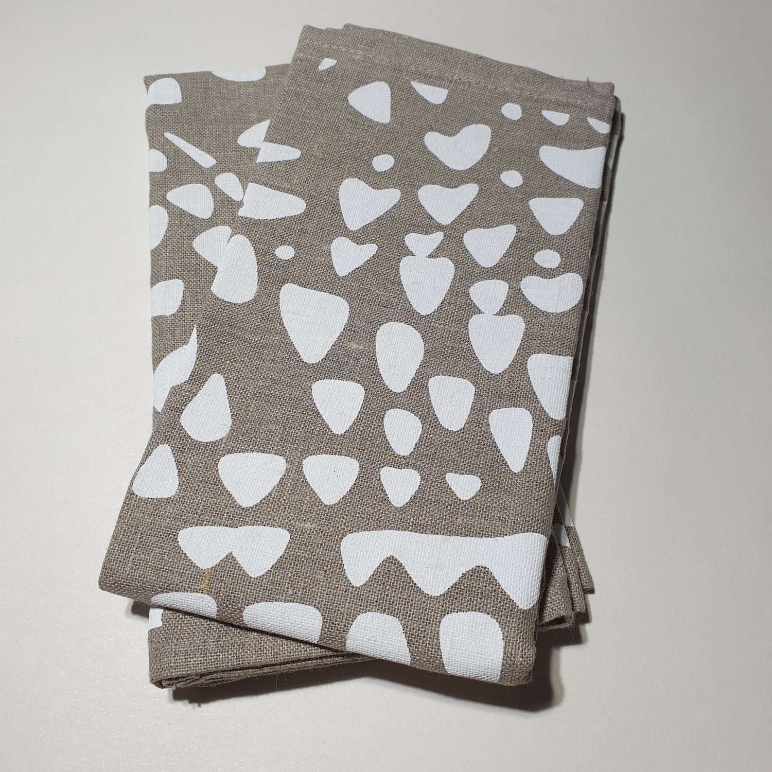 Natural linen serviettes with white pattern