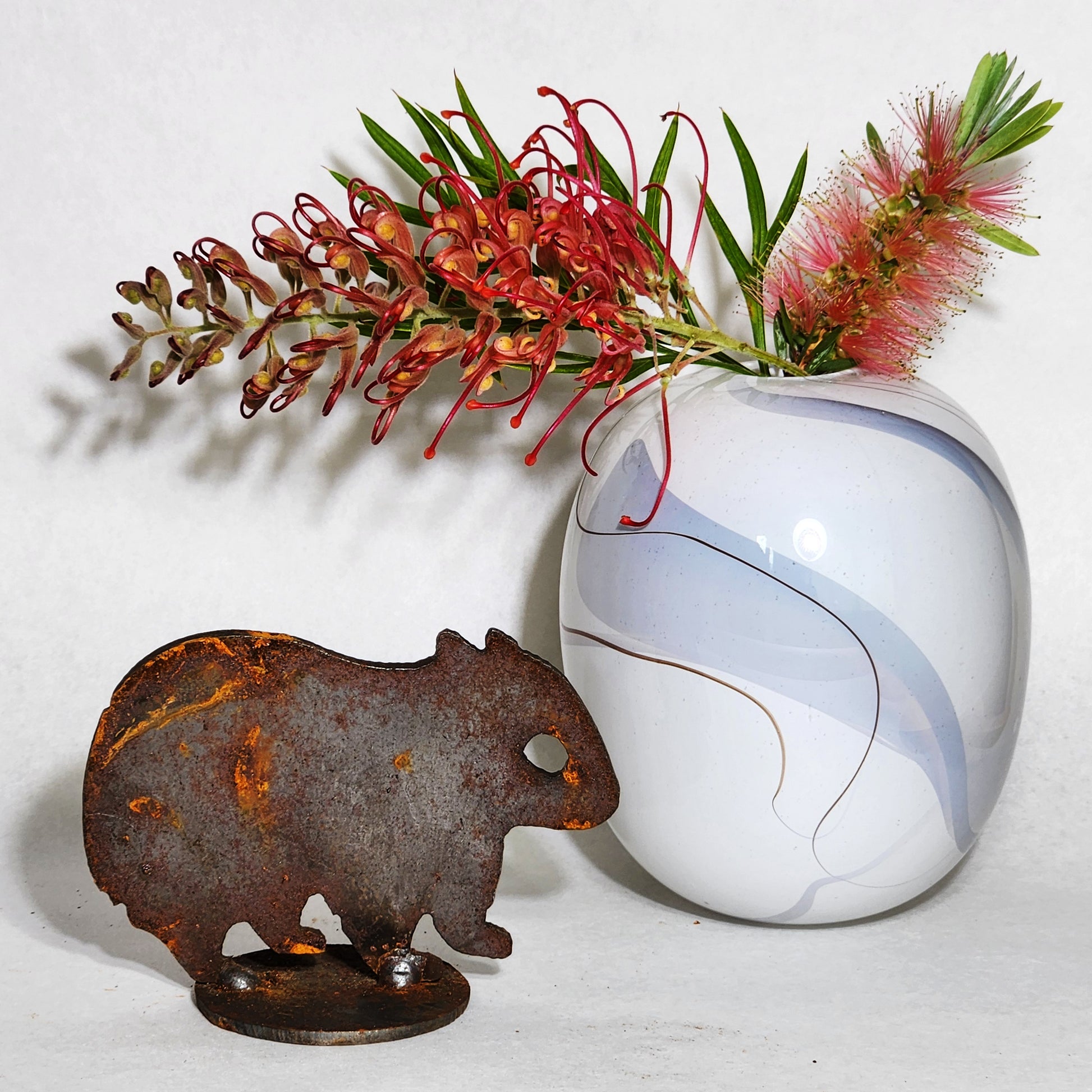 Rustic steel wombat garden ornament from Ninapatina with a vase of native flowers